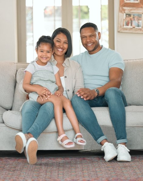 Familia sentada en sofa sonriendo