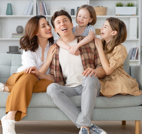 Familia sentada en sofa sonriendo